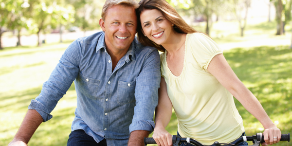 Mature couple riding bicycles in the park 176993897_3869x2579